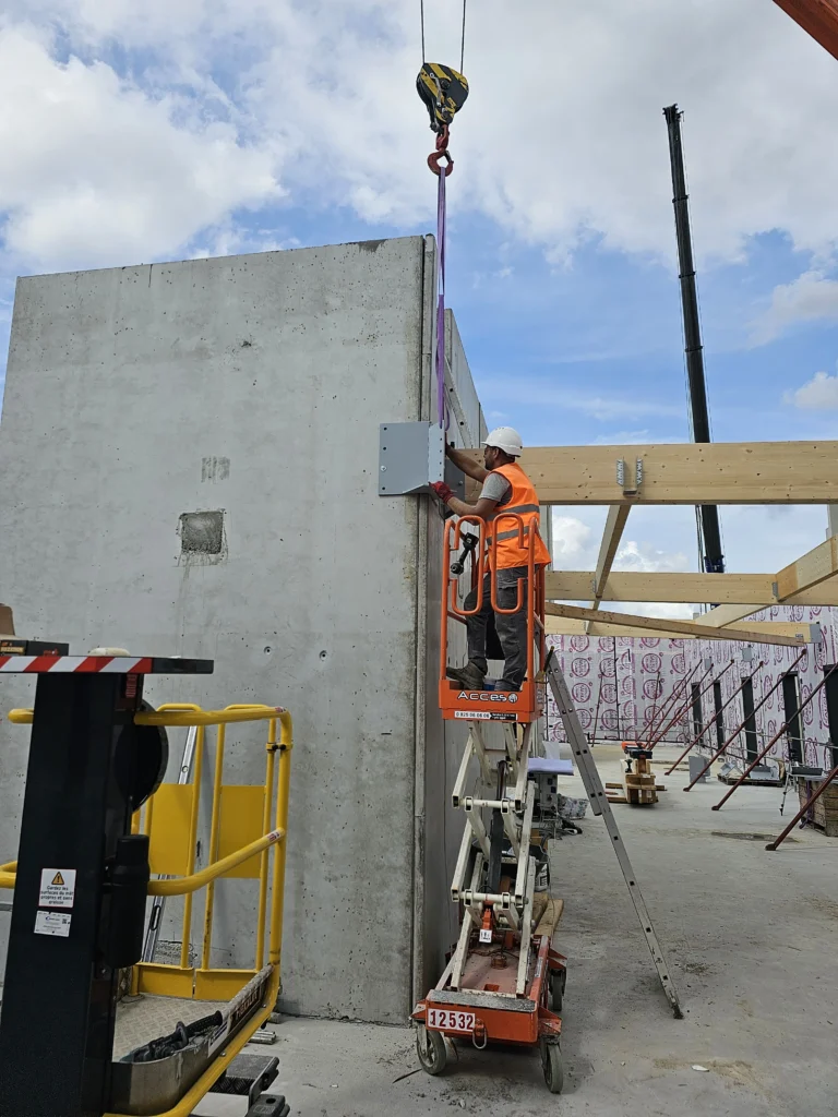 photo de deux ouvriers en train de fixer une charpente en bois à l'aide d'un élevateur