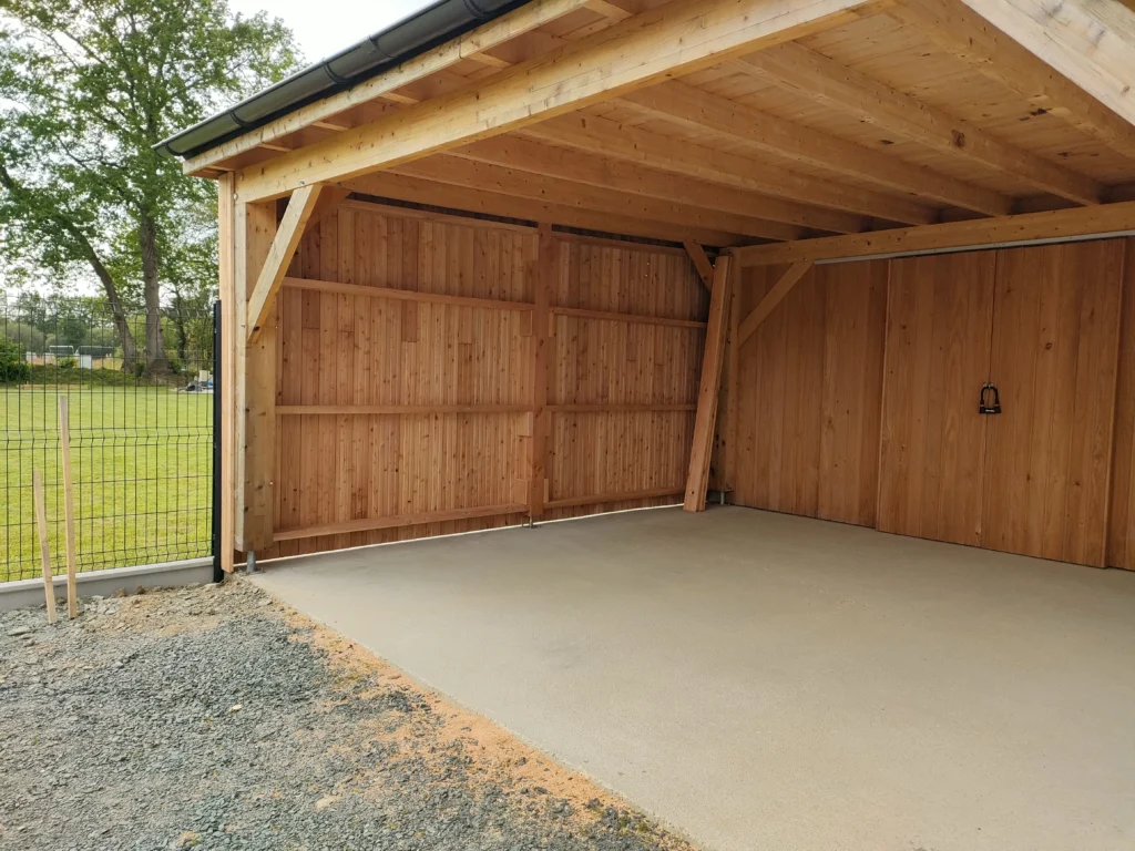 photo d'un préau en bois dans un jardin avec dalle béton